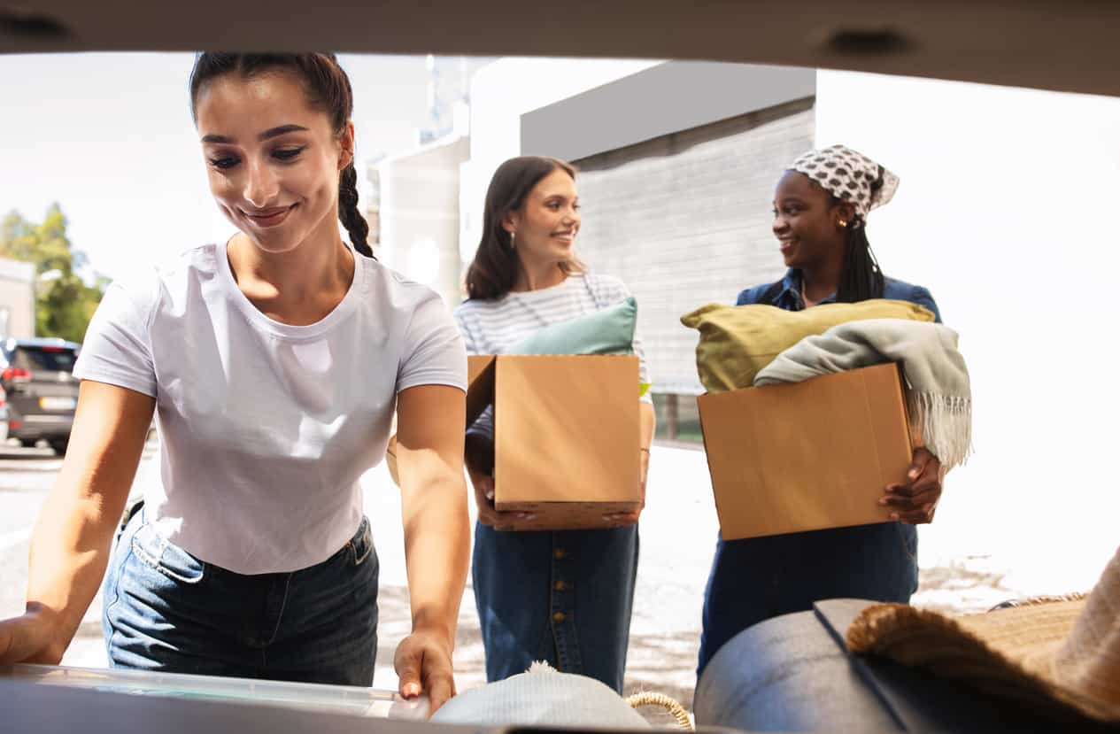 Mulheres organizando caixas com seus pertences durante uma mudança compartilhada